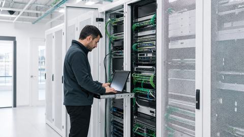 Data center engineer working on enterprise network infrastructure in a modern server room